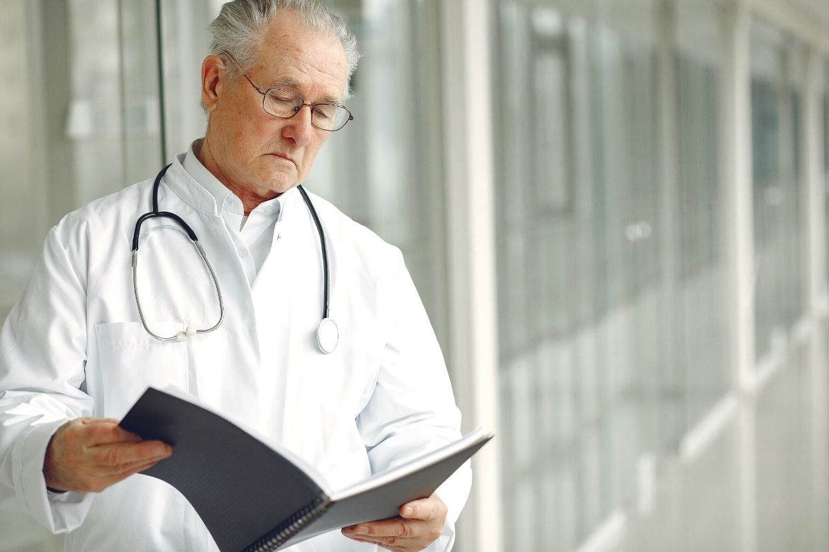 Doctor leyendo el historial de un paciente con una póliza Adeslas de salud